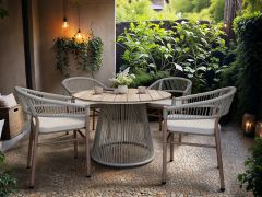Round garden table and chairs set with woven armchairs and a pedestal table, styled on a patio