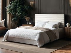Chenille ottoman bed with horizontal panel headboard and lift-up storage base in a modern bedroom with dark walls and wooden flooring.
